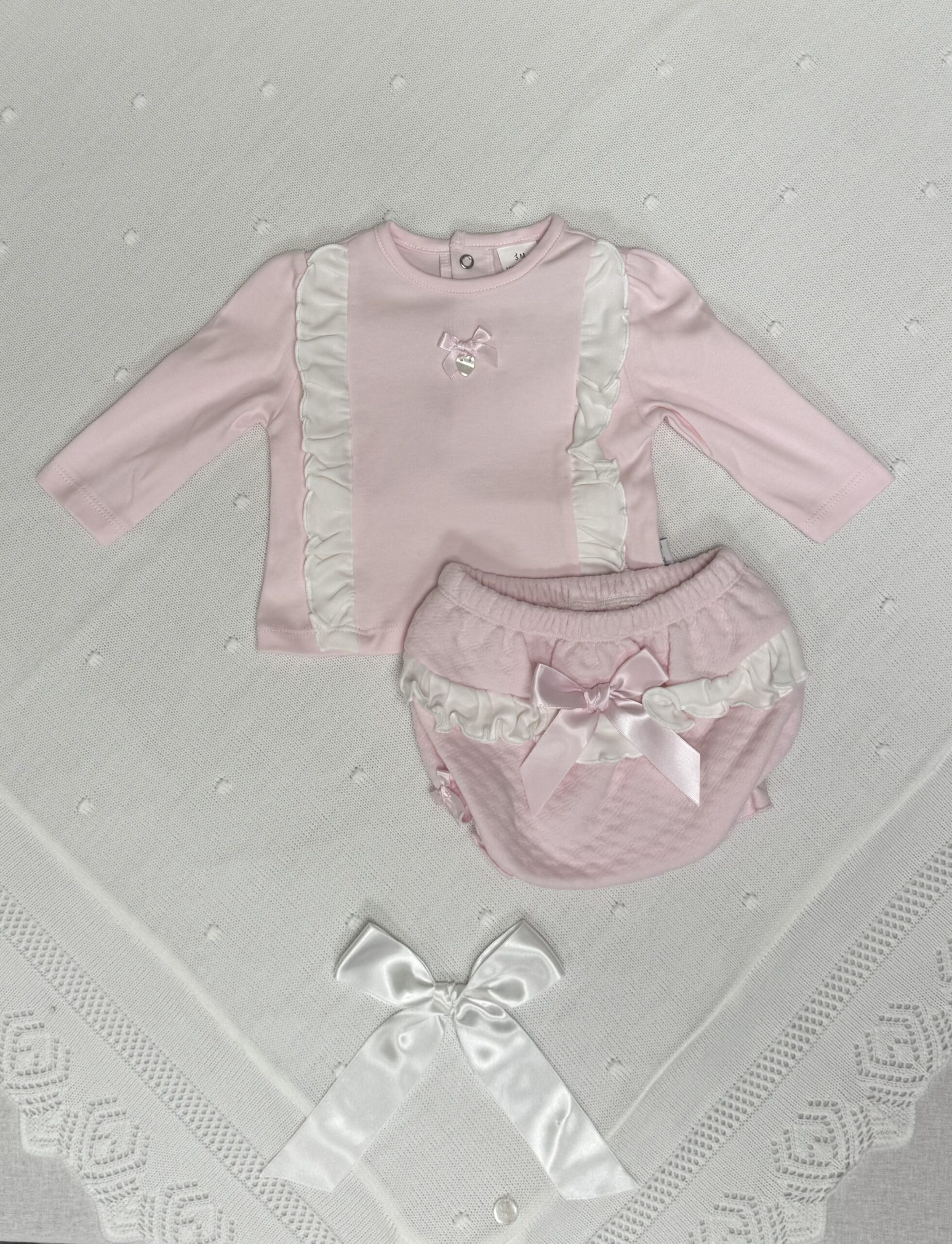 To delt sett med volangdetaljer og sløyfe